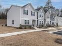 View of the townhome exteriors showcasing neutral siding and well-maintained landscaping at 2456 Tonoloway Dr, Raleigh, NC 27610