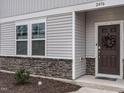 Close-up exterior showcasing the home's entryway, accented with stone and a decorative wreath at 2456 Tonoloway Dr, Raleigh, NC 27610