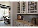 Stylish butler's pantry with granite countertops, glass-front cabinets, and herringbone backsplash at 247 Gilliland Rd, Siler City, NC 27344