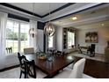 Formal dining room featuring a dark wood table, elegant chandeliers, and bright natural light at 247 Gilliland Rd, Siler City, NC 27344