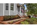 Close-up of home entrance with gray siding, brick foundation, and well-maintained landscaping at 301 Tillamook Dr, Wake Forest, NC 27587