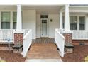 Welcoming front porch with white railings, brick accents, and a wooden ramp leading to the entrance at 308 Charles St, Henderson, NC 27536