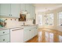 Charming kitchen boasting robin's egg blue cabinets, white countertops, and a chandelier-lit breakfast nook at 3700 Baron Cooper Pass # 104, Raleigh, NC 27612