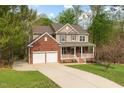 Two-story home boasts a long driveway and attached two-car garage, showcasing a well-manicured lawn at 3729 Norman Blalock Rd, Willow Springs, NC 27592