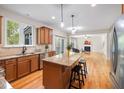 Open kitchen with granite island, stainless appliances, and wood floors flowing into the living room at 3729 Norman Blalock Rd, Willow Springs, NC 27592