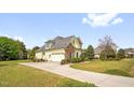 View of the home's side exterior and driveway, highlighting the architectural style and curb appeal at 432 Kings Hollow Dr, Raleigh, NC 27603