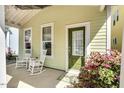 Inviting covered front porch with chairs and a decorative front door at 45 Summersweet Ln, Chapel Hill, NC 27516