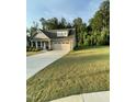 Beautifully maintained lawn of a home with stone accents and an attached two car garage at 53 Azul Dr, Clayton, NC 27520