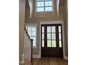 Elegant entryway featuring a wooden door, hardwood floors, and a staircase at 5480 Thom Rd, Mebane, NC 27302