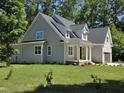 Charming two-story home with a covered front porch, lush green lawn, and attached two-car garage at 5480 Thom Rd, Mebane, NC 27302