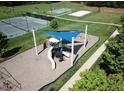 Outdoor play area with slides and sunshade for children, next to the tennis and basketball courts at 7 Brandon Pines Ct, Pittsboro, NC 27312