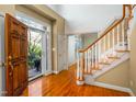 Inviting foyer with hardwood floors, staircase, and natural light streaming through the front door at 702 Orange Dr, Elon, NC 27244
