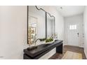 Bright entryway featuring a console table with decor, large mirrors, and a view of the front door at 712 Holstein Dairy Way, Wake Forest, NC 27587