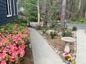 Well-maintained yard featuring lush pink azaleas, bird bath, and mature trees at 7429 Ashbury Ct, Raleigh, NC 27615