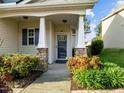 Inviting front porch with stone accents and colorful landscaping, creating a warm entry at 814 Ember Dr, Durham, NC 27703
