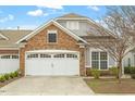 Attractive home exterior with a stone and siding facade, and a spacious two-car garage at 830 Finnbar Dr, Cary, NC 27519