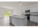 Modern kitchen featuring an island, stainless steel appliances, and granite countertops at 841 Kenyon Spring Dr, Zebulon, NC 27597
