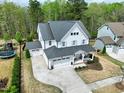 Aerial view of a beautiful two-story home with a spacious driveway and lush green surroundings at 853 Rambling Oaks Ln, Holly Springs, NC 27540