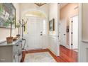 Bright foyer with hardwood floors and a lovely cabinet offers a welcoming entrance to the home at 9 Hayden Pond Ln, Chapel Hill, NC 27517