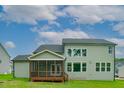Back exterior features a screened porch and large windows overlooking a spacious backyard under a bright sky at Lot 1 Northpointe Farms Trl, Efland, NC 27243