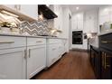 Modern kitchen with white cabinets, stainless steel appliances, and a stylish chevron backsplash design at Lot 1 Northpointe Farms Trl, Efland, NC 27243