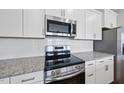 Close up of stainless appliances, subway tile backsplash and granite countertops at 100 Ripple Way # 317, Clayton, NC 27520