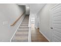 Carpeted stairs with wood railing lead to the second floor of this modern home at 100 Ripple Way # 317, Clayton, NC 27520