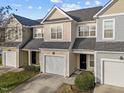 Street view of townhomes with single car garages and green lawns at 10133 Bessborough Dr, Raleigh, NC 27617