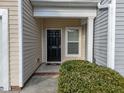 Front door of townhome displaying address with small landscaped garden at 10133 Bessborough Dr, Raleigh, NC 27617