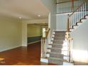 Bright foyer with hardwood floors, staircase, and an open view into the adjacent dining room at 109 Bright Shade Ct, Holly Springs, NC 27540