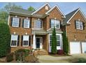 Traditional brick home with a well-manicured lawn, tidy landscaping and an attached two-car garage at 109 Bright Shade Ct, Holly Springs, NC 27540