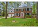 Traditional brick home featuring well-manicured lawn, dormer windows, and an attached two-car garage at 114 Oxpens Rd, Cary, NC 27513