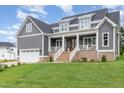 Beautiful gray two-story home with a welcoming covered front porch and manicured lawn at 1221 Azalea Garden Cir, Raleigh, NC 27603