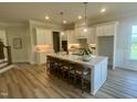 Spacious kitchen with a large center island, white cabinets, and hardwood floors at 1221 Azalea Garden Cir, Raleigh, NC 27603
