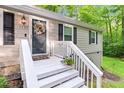 Attractive front entrance with a black door, white railings, and flower decoration at 1332 Stallings Rd, Chapel Hill, NC 27516
