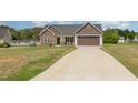 Single-story home with stone facade, a two-car garage, and green lawn at 158 Blande Dr, Kenly, NC 27542