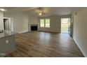 Spacious living room featuring wood floors, a cozy fireplace, and large windows for ample natural light at 170 Eason Creek Way, Clayton, NC 27527