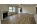 Bright living room with wood floors, a fireplace, and a view to the entry door and outside at 170 Eason Creek Way, Clayton, NC 27527