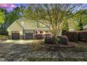 Charming home with a two-car garage, lush landscaping, and an American flag displayed in the front yard at 181 Fawn Hill Ct, Garner, NC 27529