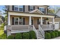 Inviting front porch with stone accents, white columns, and green landscaping at 189 Grey Hawk Dr, Garner, NC 27529
