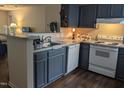 Well-lit kitchen with stainless steel appliances, dark cabinetry, and wood flooring at 1911 Wolftech Ln # 204, Raleigh, NC 27603
