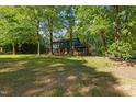 Exterior view of a two-story home with blue siding, brick accents and surrounded by mature trees at 204 N Gurney St, Burlington, NC 27215