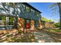 Close up view of a two-story home with blue siding, brick accents, black shutters and a red front door at 204 N Gurney St, Burlington, NC 27215