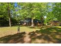 Beautiful front yard with mature trees shading a two-story home with blue siding and brick accents at 204 N Gurney St, Burlington, NC 27215