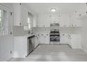 Bright kitchen featuring stainless steel appliances, white cabinets, and modern countertops and fixtures at 2400 Hemlock Cir, Clayton, NC 27520