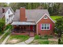Beautiful red brick home with covered front porch and pink window shutters at 2724 N Roxboro St, Durham, NC 27704
