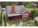 Beautiful red brick home with covered front porch and pink window shutters at 2724 N Roxboro St, Durham, NC 27704