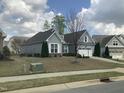 Well-maintained single Gathering home boasts a two-car garage, mature trees, and a tidy front lawn at 338 Apalachia Lake Dr, Fuquay Varina, NC 27526