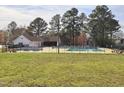 Community pool featuring ample seating, clubhouse, fenced perimeter and a well manicured lawn at 3421 E E Jameson Rd, Raleigh, NC 27604