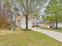 View of the 2-car garage and driveway of this lovely home and a brick house next to it at 3705 Andoversford Ct, Wake Forest, NC 27587